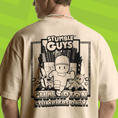 Load image into Gallery viewer, Beige t-shirt with 'Stumble Guys' graphic on a green background