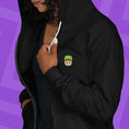 Load image into Gallery viewer, Person wearing a hoodie with a Mr. Stumble embroidered design on the chest against a purple background
