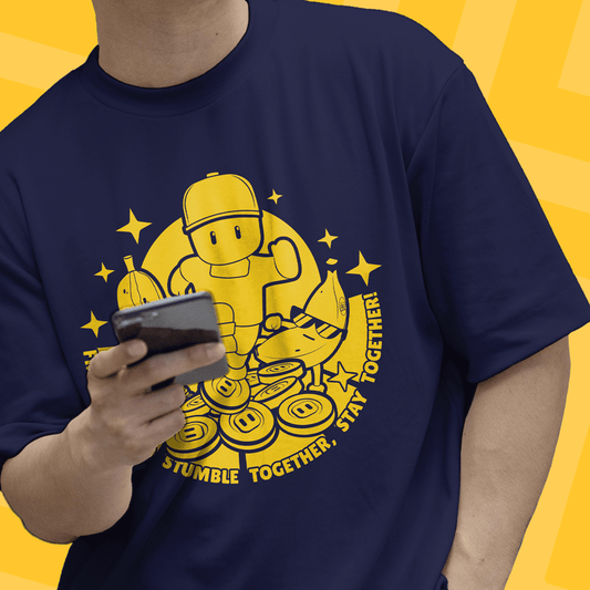 Person wearing a navy blue t-shirt with yellow Stumble Guys graphic design a yellow background